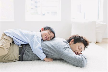 relieved person happy - Young boy laying on his fathers back Stock Photo - Premium Royalty-Free, Code: 622-08139005