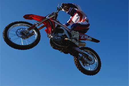 Motocross biker jumping over dirt track Photographie de stock - Premium Libres de Droits, Code: 622-08355498