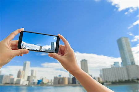 Japanese woman using augumented reality app on smartphone downtown Tokyo, Japan Stock Photo - Premium Royalty-Free, Code: 622-08839811