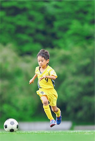 soccer player kicking ball into the goal - Japanese kid playing soccer Stock Photo - Premium Royalty-Free, Code: 622-08893925