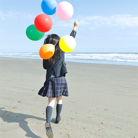 pictures of a girl back - Young Japanese woman in a high school uniform running with balloons by the sea, Chiba, Japan Stock Photo - Premium Royalty-Free, Code: 622-08949160