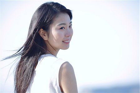 smiling one person - Young Japanese woman in a white dress by the sea, Chiba, Japan Foto de stock - Sin royalties Premium, Código: 622-08949306