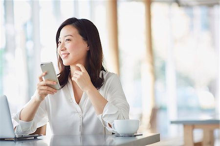 simsearch:6109-08690411,k - Japanese woman with smartphone in a stylish cafe Stock Photo - Premium Royalty-Free, Code: 622-09014308