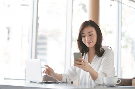 simsearch:6109-08690411,k - Japanese woman with smartphone in a stylish cafe Stock Photo - Premium Royalty-Free, Code: 622-09014693