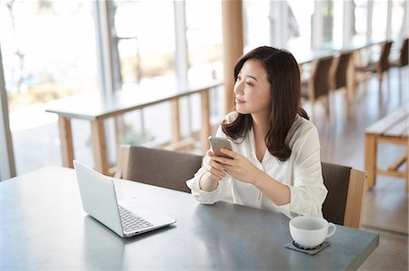 simsearch:6109-08690411,k - Japanese woman with smartphone in a stylish cafe Stock Photo - Premium Royalty-Free, Code: 622-09014702