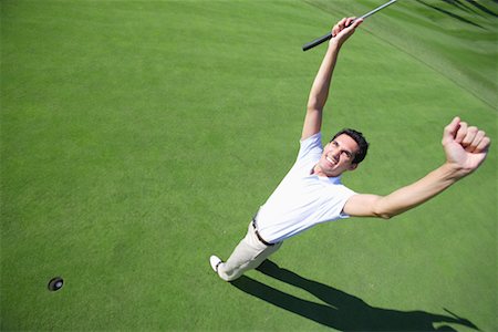 Male golfer clenching his fists in excitement after a making a putt Stock Photo - Premium Royalty-Free, Code: 622-00807032