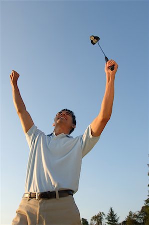 Man raising his hands in excitement after making a winning putt Stock Photo - Premium Royalty-Free, Code: 622-00807125
