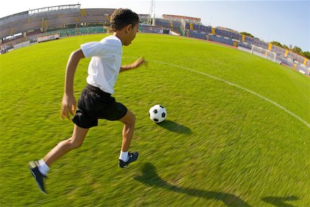 Boy dribbling a ball Stock Photo - Premium Royalty-Free, Code: 622-01283664