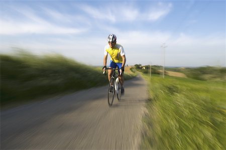 Front view of a man cycling on road Stock Photo - Premium Royalty-Free, Code: 622-02198571