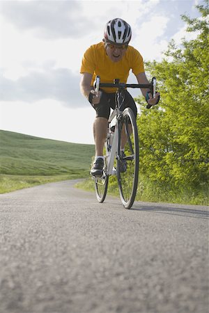 Front view of a man cycling on road Stock Photo - Premium Royalty-Free, Code: 622-02198580