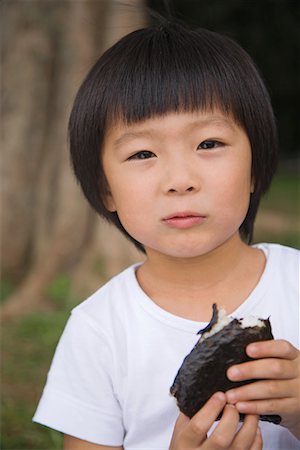 Boy eating chocolate cake and looking at camera Stock Photo - Premium Royalty-Free, Code: 622-02354141