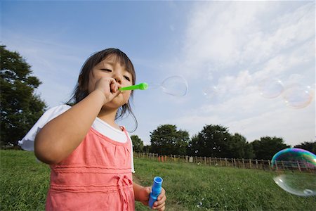 simsearch:632-05604245,k - Girl blowing soap bubbles in park Stock Photo - Premium Royalty-Free, Code: 622-02354150