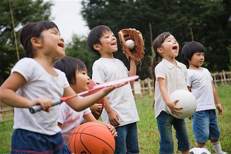 friends playing football - Children holding sports equipments Stock Photo - Premium Royalty-Free, Code: 622-02354173