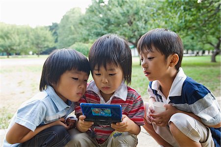 simsearch:614-06896931,k - Trois garçons jouant des jeux vidéo portatif, Suginami, Tokyo, région de Kanto, Honshu, Japon Photographie de stock - Premium Libres de Droits, Code: 622-02354276