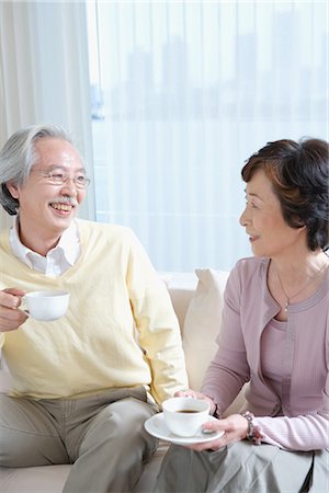 elder care - Senior couple having coffee on couch in living room Stock Photo - Premium Royalty-Free, Code: 622-02759143