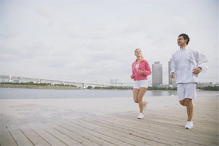 Young couple jogging on wharf Stock Photo - Premium Royalty-Free, Code: 622-02913297