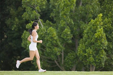 fortitude - Young Woman in tank top jogging on grass Stock Photo - Premium Royalty-Free, Code: 622-02913320