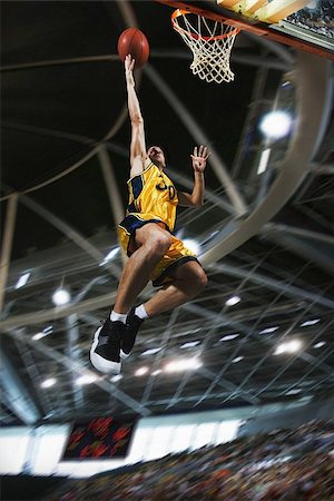 simsearch:649-07239531,k - Young man holding basketball jumping in air Stock Photo - Premium Royalty-Free, Code: 622-02913436