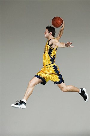 players in action for goal - Young man jumping and holding basketball Stock Photo - Premium Royalty-Free, Code: 622-02913442