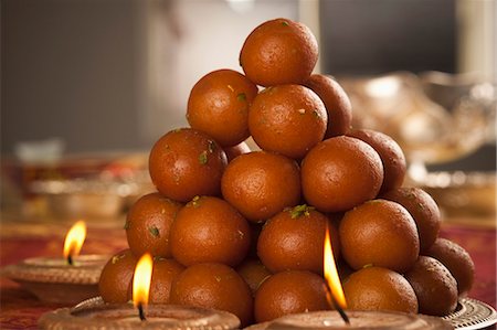 pistachio - Candles burning around a tray of gulab jamuns Stock Photo - Premium Royalty-Free, Code: 630-06724453