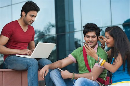 University students listening to music on a mobile phone Stock Photo - Premium Royalty-Free, Code: 630-06724579