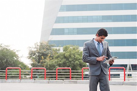 Businessman using a digital tablet, Gurgaon, Haryana, India Stock Photo - Premium Royalty-Free, Code: 630-06724615