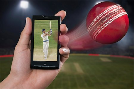 Man watching a cricket match on a mobile phone Stock Photo - Premium Royalty-Free, Code: 630-06724640