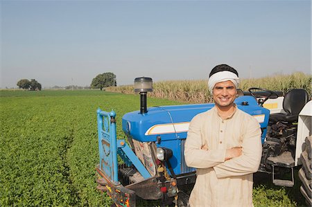 farm images of happy people - Farmer standing near a tractor in the field, Sonipat, Haryana, India Stock Photo - Premium Royalty-Free, Code: 630-06724671