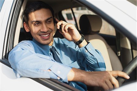 driving in asia - Bengali businessman talking on a mobile phone while driving a car Foto de stock - Sin royalties Premium, Código: 630-06724889