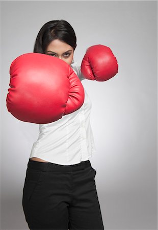 Businesswoman punching with boxing gloves Stock Photo - Premium Royalty-Free, Code: 630-06722009