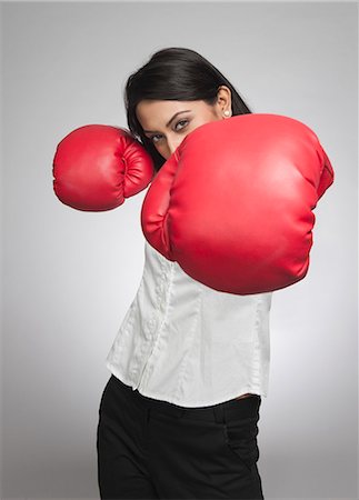 Businesswoman punching with boxing gloves Stock Photo - Premium Royalty-Free, Code: 630-06722010