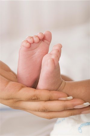 relaxing indoor legs - Baby feet on a woman's hand Stock Photo - Premium Royalty-Free, Code: 630-06722562