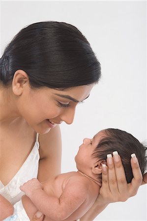 Woman carrying her baby and smiling Stock Photo - Premium Royalty-Free, Code: 630-06722579