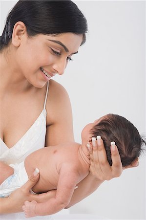 east indian mother and children - Woman carrying her baby and smiling Stock Photo - Premium Royalty-Free, Code: 630-06722580