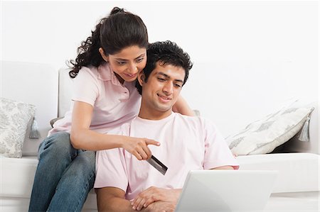 Couple using a laptop and holding a credit card Stock Photo - Premium Royalty-Free, Code: 630-06722746