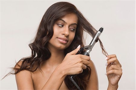 simsearch:6108-05869257,k - Woman using straightening irons on her hair Stock Photo - Premium Royalty-Free, Code: 630-06722955