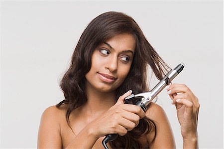 simsearch:6108-05869249,k - Woman using straightening irons on her hair Stock Photo - Premium Royalty-Free, Code: 630-06722956