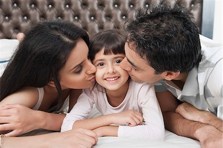 Parents kissing their daughter Stock Photo - Premium Royalty-Free, Code: 630-06723092