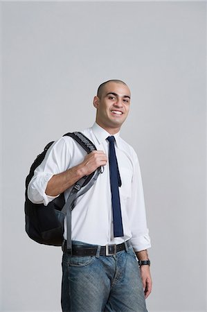 Businessman carrying a backpack and smiling Stock Photo - Premium Royalty-Free, Code: 630-06723234