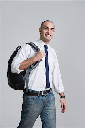 Businessman carrying a backpack and smiling Stock Photo - Premium Royalty-Free, Code: 630-06723235