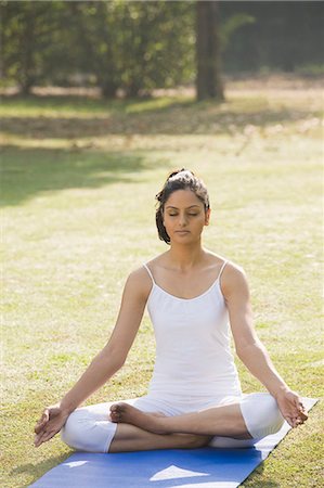 Woman meditating in a park Stock Photo - Premium Royalty-Free, Code: 630-06723396