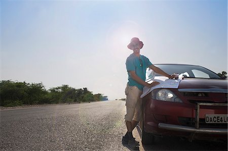 road map - Man holding a map on a car hood Stock Photo - Premium Royalty-Free, Code: 630-06723501