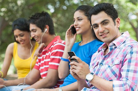 simsearch:700-01200131,k - Friends using mobile phones and mp3 player in a park, Lodi Gardens, New Delhi, Delhi, India Stock Photo - Premium Royalty-Free, Code: 630-07071387