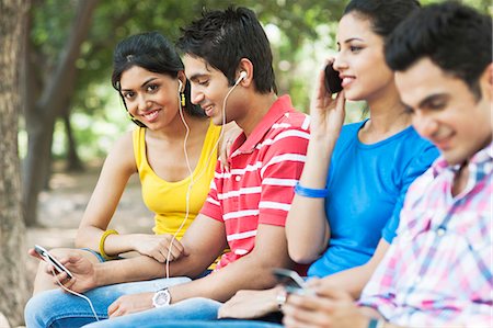 simsearch:700-01200131,k - Friends using mobile phones and mp3 player in a park, Lodi Gardens, New Delhi, Delhi, India Stock Photo - Premium Royalty-Free, Code: 630-07071389