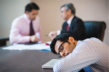 simsearch:630-07071502,k - Businessman sleeping in a conference with two businessmen in the background Stock Photo - Premium Royalty-Free, Code: 630-07071464