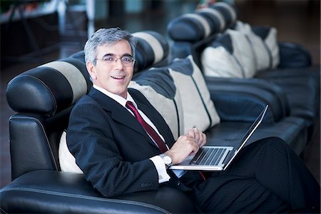 simsearch:630-07071502,k - Businessman working on a laptop at an airport lounge Stock Photo - Premium Royalty-Free, Code: 630-07071469