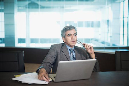 simsearch:630-07071502,k - Businessman sitting in front of laptop lost in thoughts Stock Photo - Premium Royalty-Free, Code: 630-07071489