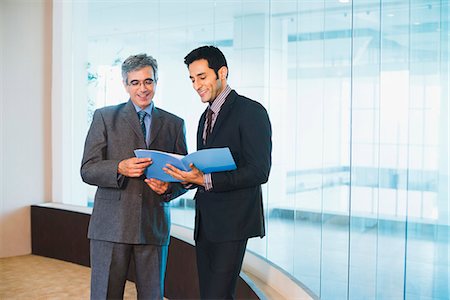 simsearch:630-07071502,k - Businessman discussing a report with his colleague Stock Photo - Premium Royalty-Free, Code: 630-07071500