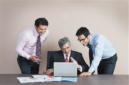 simsearch:630-07071502,k - Business executives looking at a laptop and smiling Stock Photo - Premium Royalty-Free, Code: 630-07071534