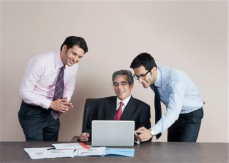 simsearch:630-07071502,k - Business executives looking at a laptop and smiling Stock Photo - Premium Royalty-Free, Code: 630-07071535